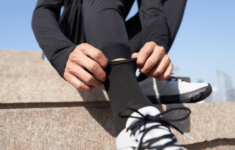 Persona arreglando su calcetín antes de correr
